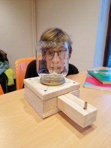 Visage d'enfant derrière un bocal, déformé de manière amusante par le verre