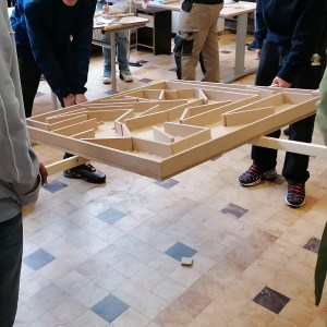 Des enfants jouent à un jeu en bois : labyrinthe