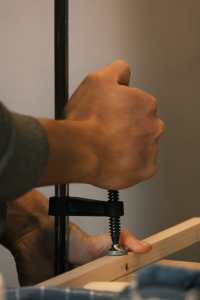 Des mains utilisent un serre-joint